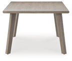 Beige rectangular dining table with square corners and four tapered legs