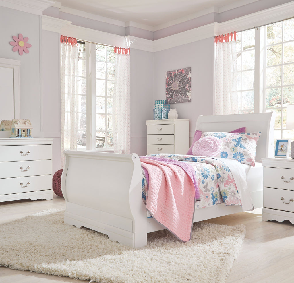 White sleigh bed headboard with rounded corners, floral duvet, and pillows