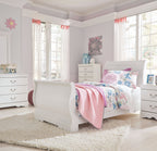 White sleigh bed headboard with rounded corners, floral duvet, and pillows