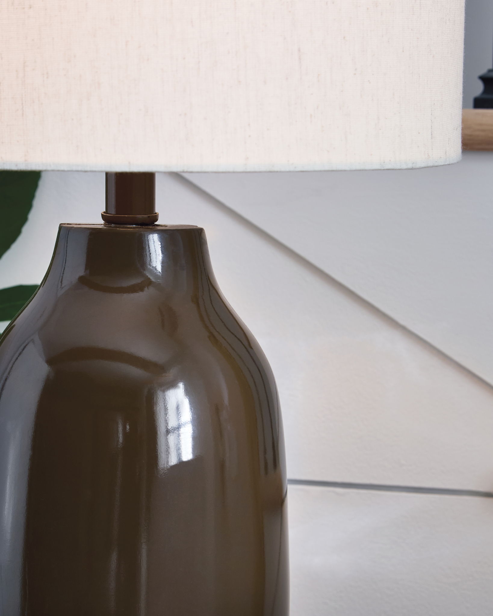 Brown glossy ceramic lamp base under a white drum shade