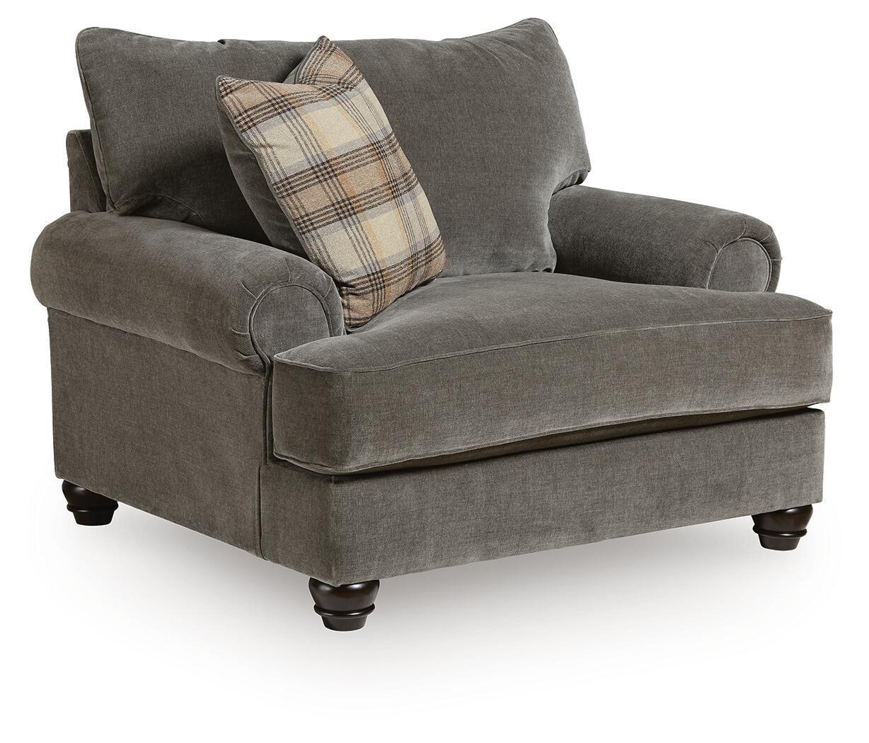 Gray chair-and-a-half with rounded arms, tufted back cushions, and plaid accent pillow