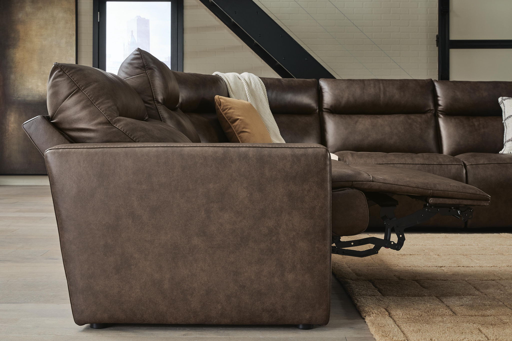 Dark brown power reclining sectional sofa with chaise footrest and throw pillows