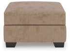 Light brown ottoman with cushioned lid and dark legs
