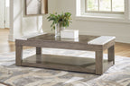 Grayish brown lift-top cocktail table with white side panels, styled with vase
