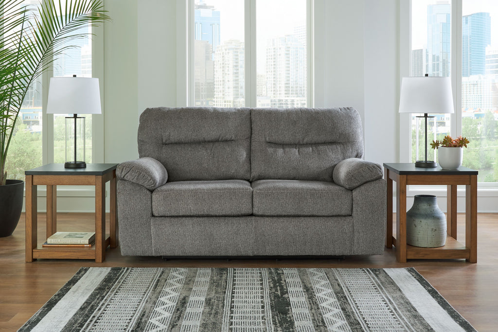 Dark gray glider loveseat with padded arms, two back cushions, and visible base legs