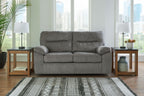 Dark gray glider loveseat with padded arms, two back cushions, and visible base legs