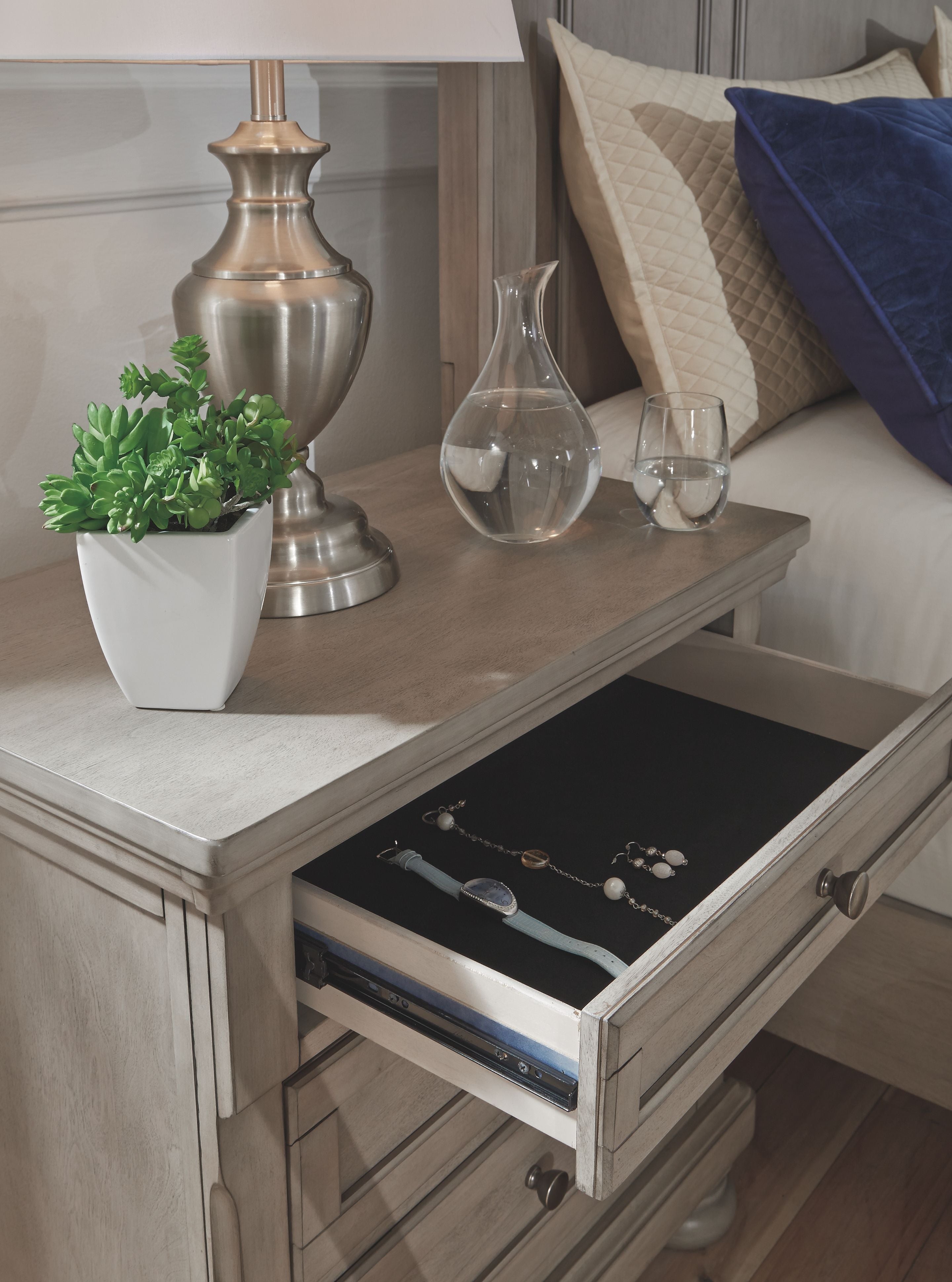 Lettner night stand with three drawers, open top drawer and open lower shelf.