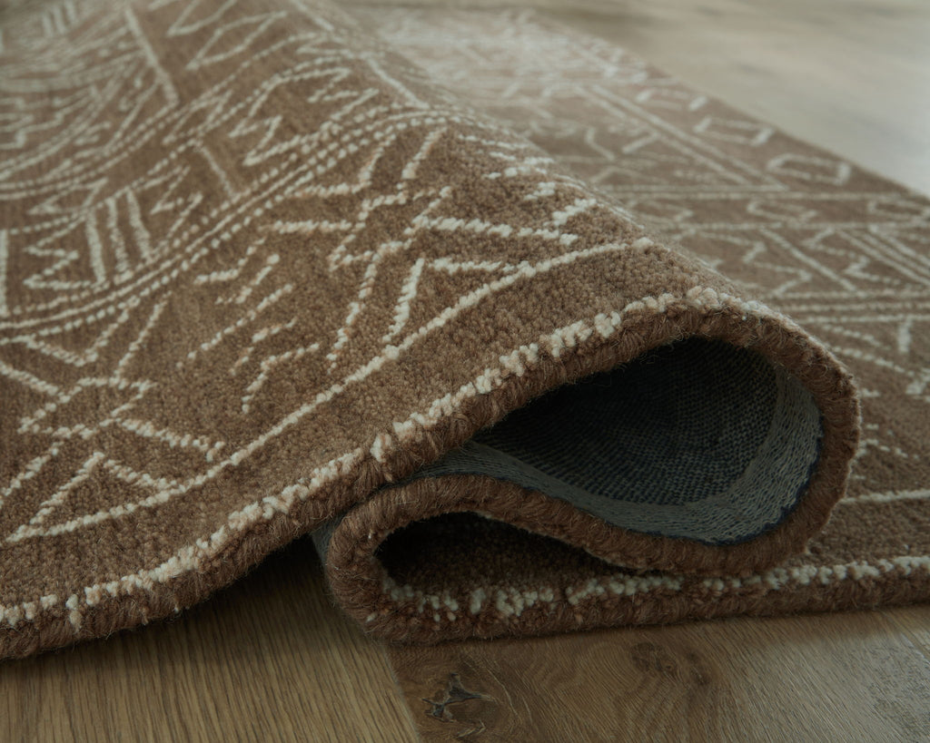 Rug corner with folded edge, dark brown geometric pattern and beige highlights