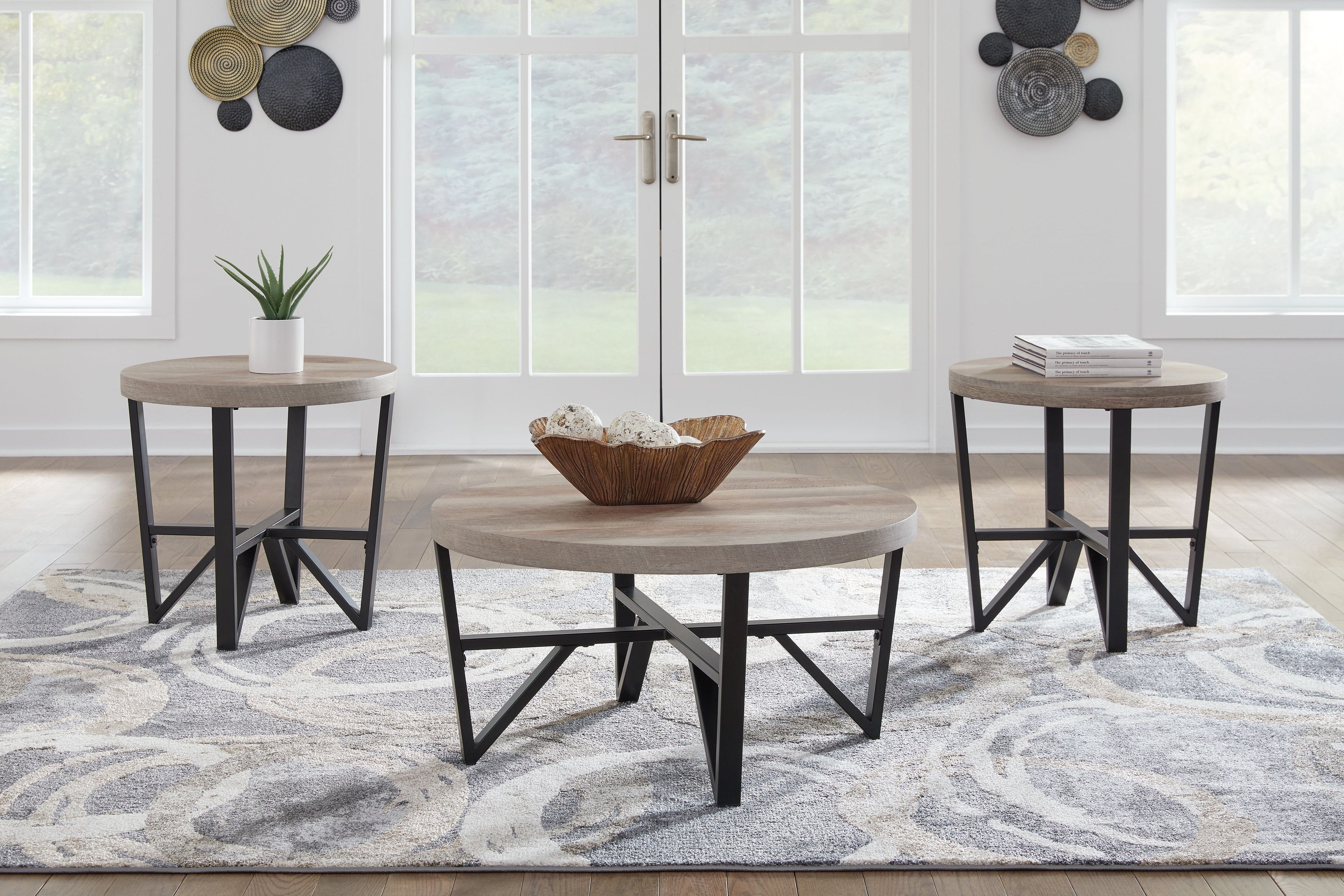 Three round nesting tables with grayish-brown tops and black metal frames