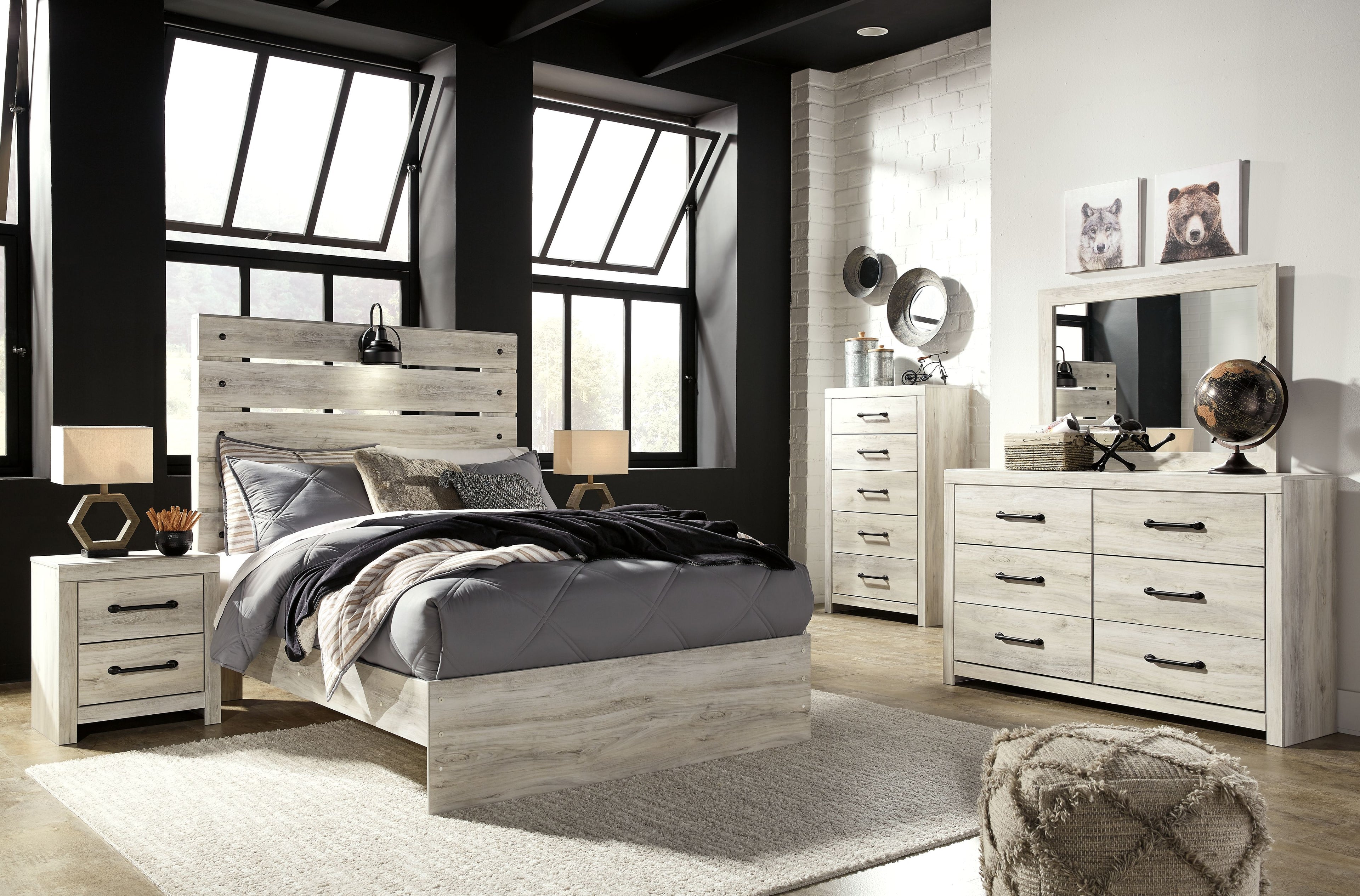 Youth bedroom set showing light wood bed with bedding and matching dresser with mirror
