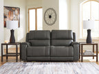 Dark gray reclining loveseat with wide padded arms and tufted seat back cushions