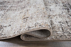 Dark gray rug edge with stitched border and visible underside backing