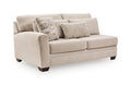Beige upholstered loveseat with square arms, two seat cushions, and decorative back pillows