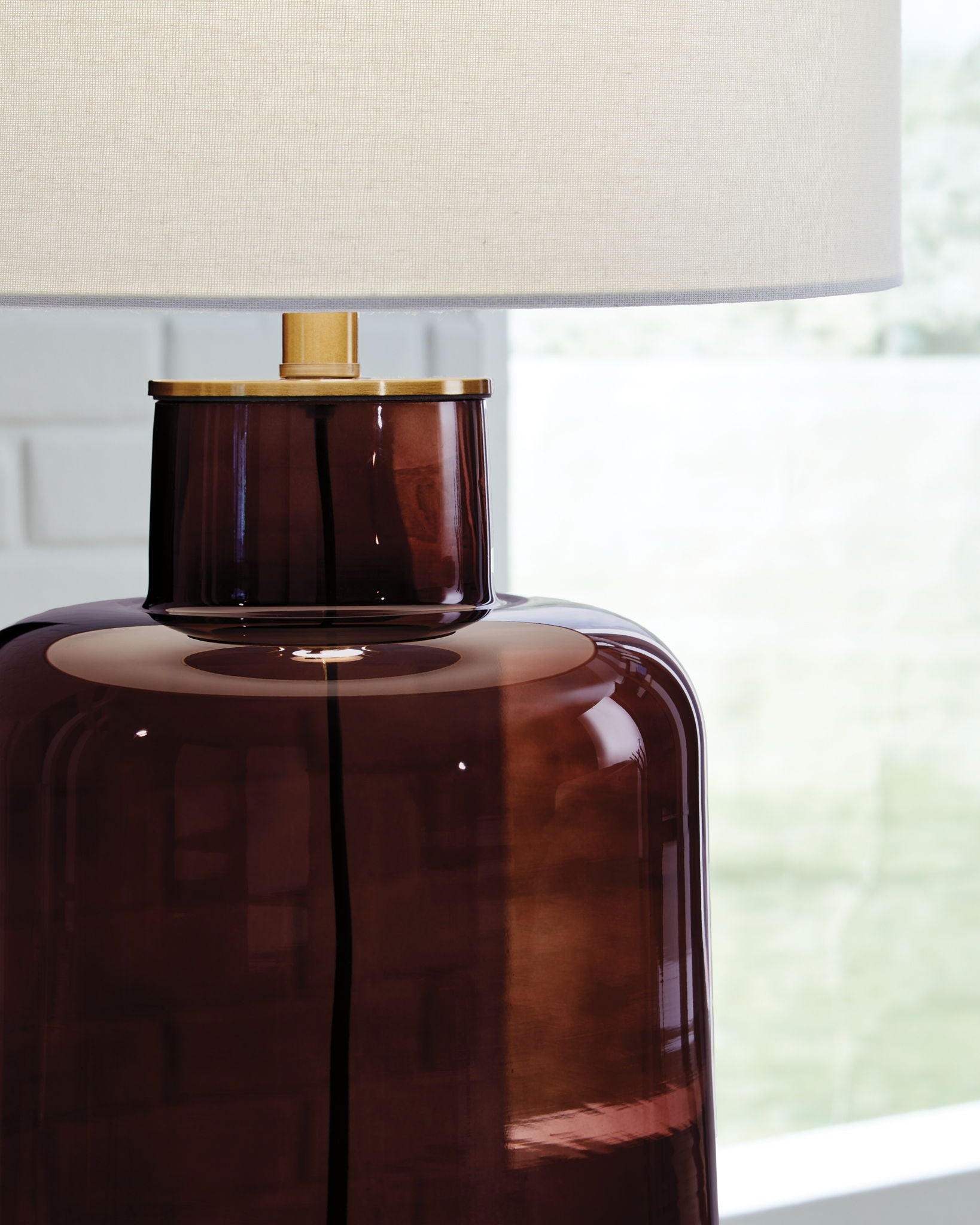 Brown amber glass table lamp with white shade and gold metal collar