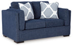 Blue loveseat sofa with two white-and-blue striped throw pillows and rounded arms
