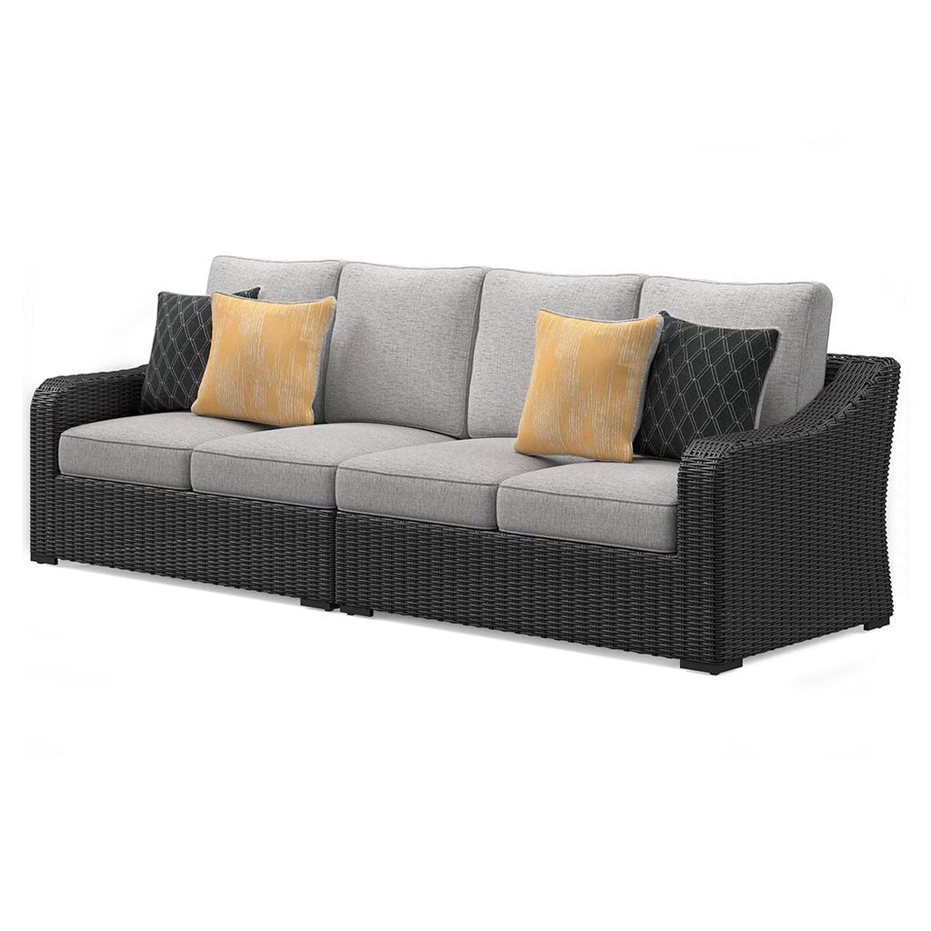 Outdoor loveseat with black wicker frame and light gray cushions, four decorative pillows