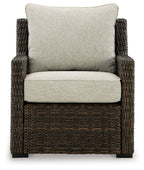 Brown woven armchair with light beige seat cushion and large back cushion