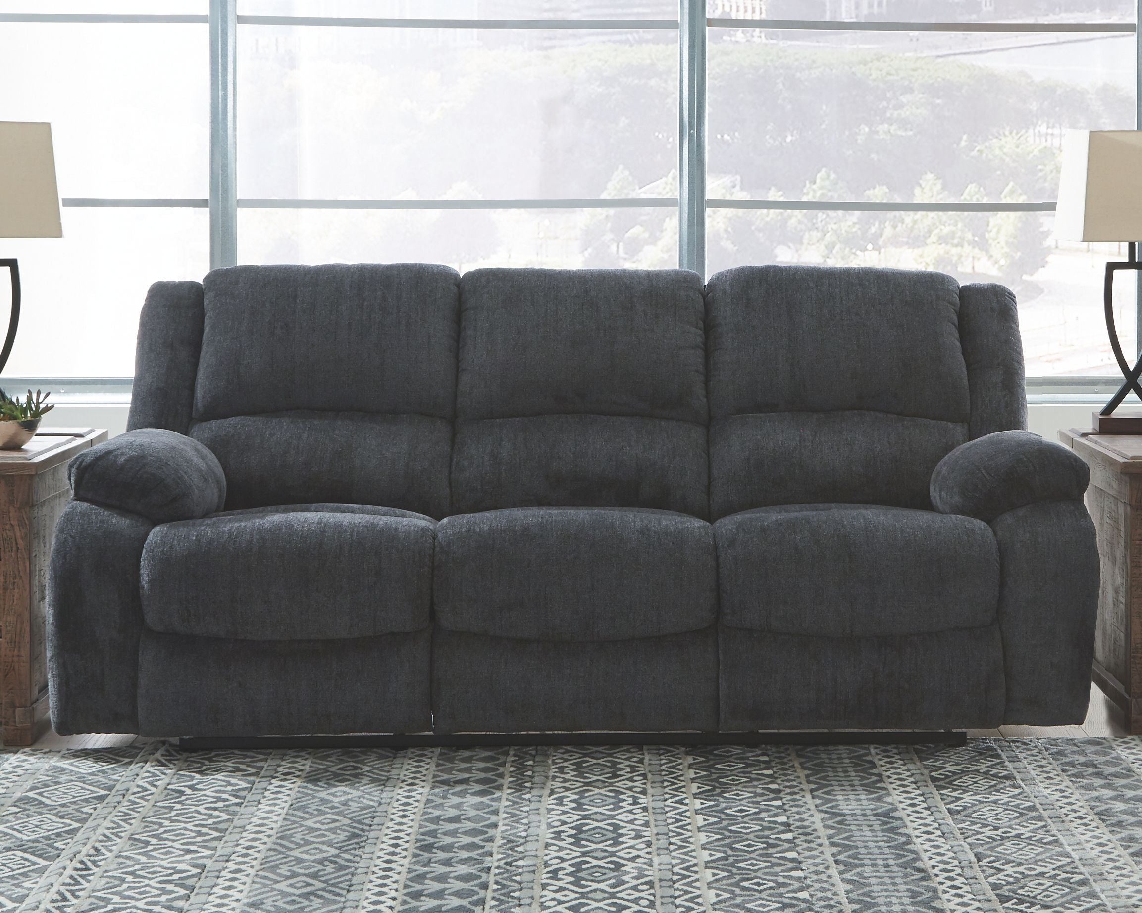 Dark gray reclining sofa with squared cushions and padded track arms