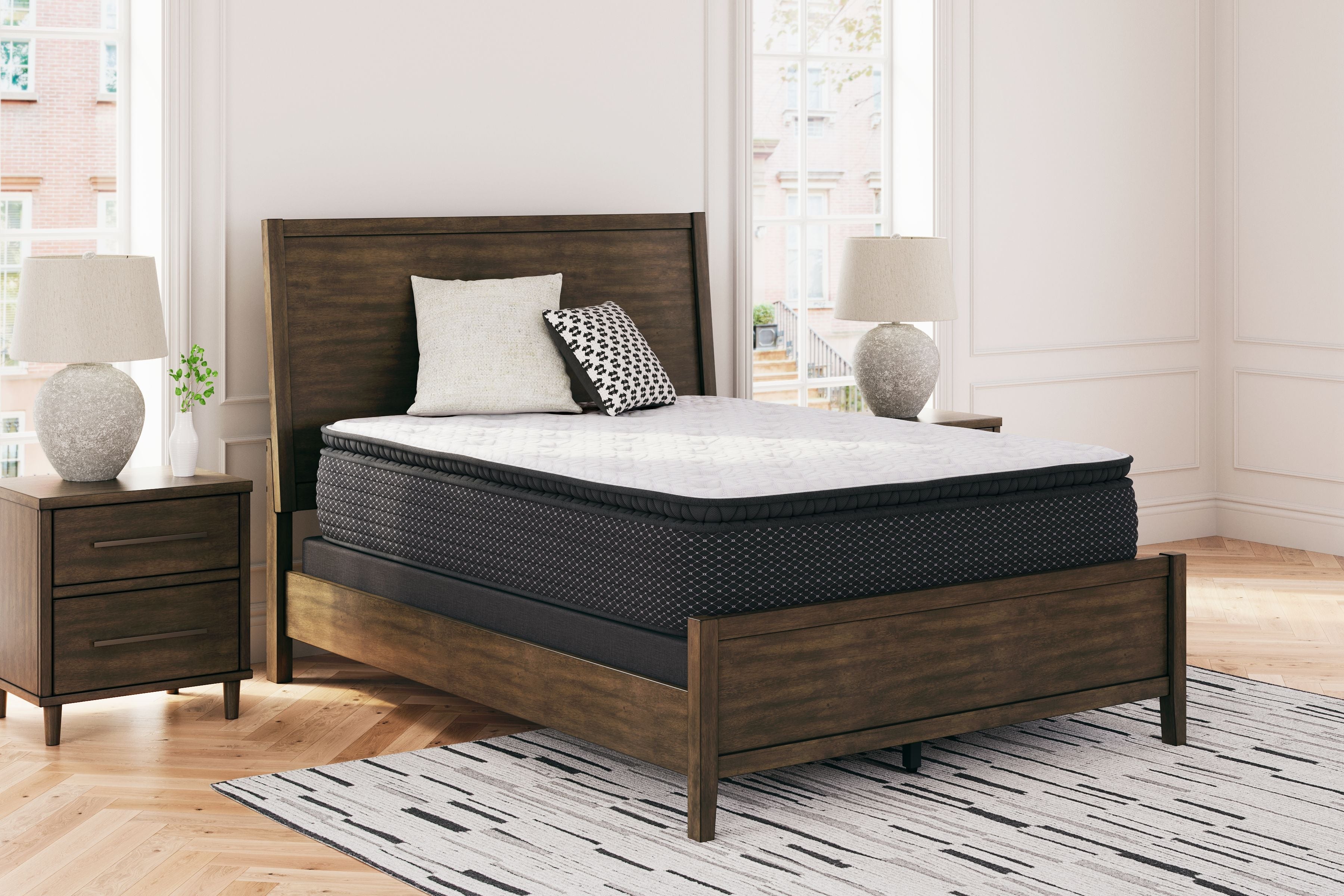 Mattress with white top and dark side panels on a platform bed frame