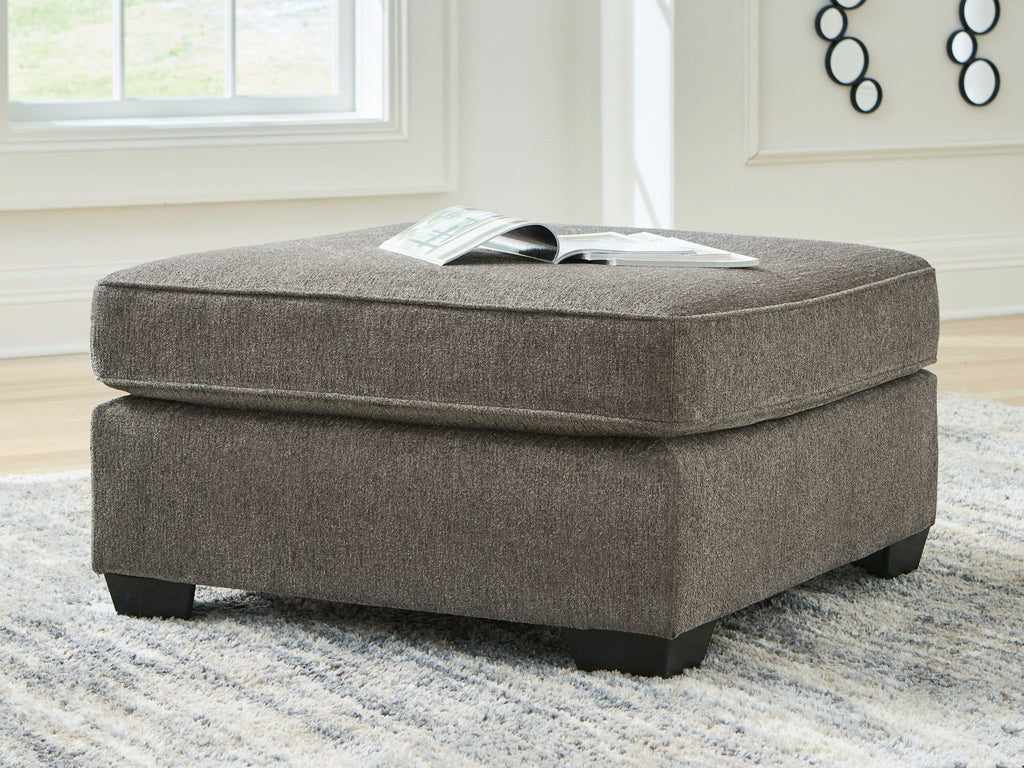 Dark gray upholstered ottoman with tufted top and squared black legs