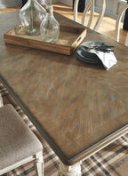 Wood dining table corner with tabletop tray and stacked plates on surface