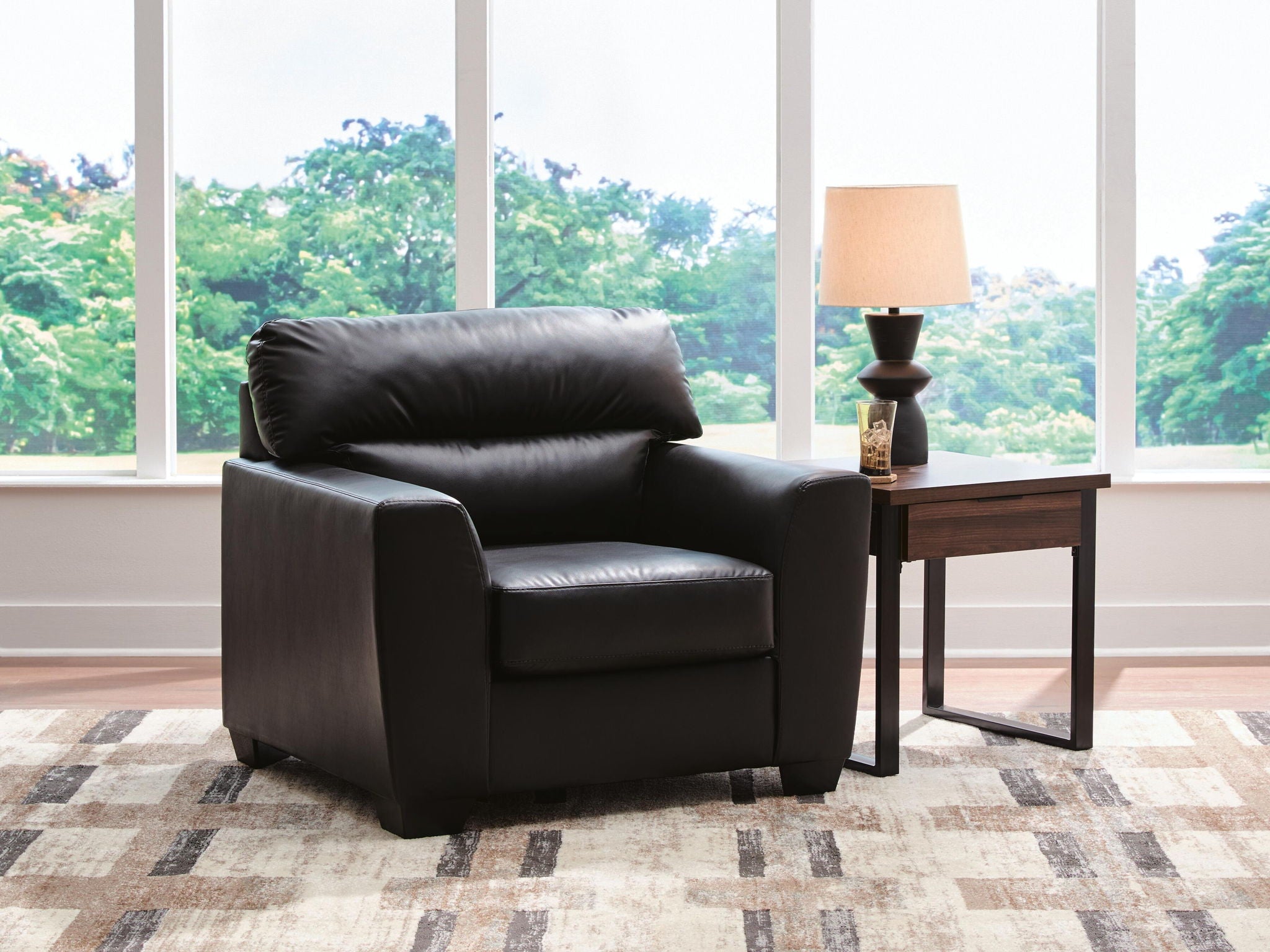 Midnight black upholstered armchair with padded seat, wide backrest, and arms