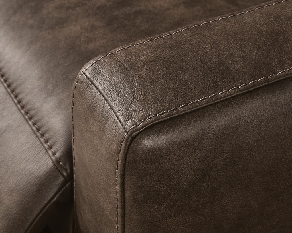 Brown upholstered sofa armrest with visible edge stitching and curved seam