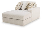 Light beige corner chaise with two patterned back pillows and single chaise cushion