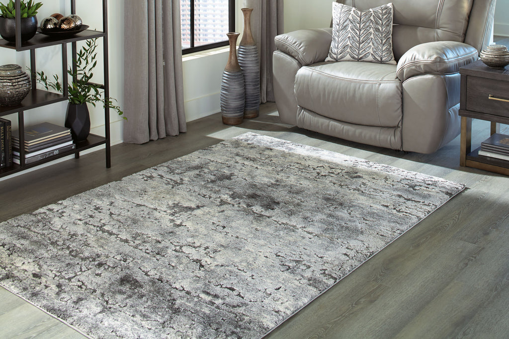 Dark gray distressed area rug, flat profile with stitched border and corner