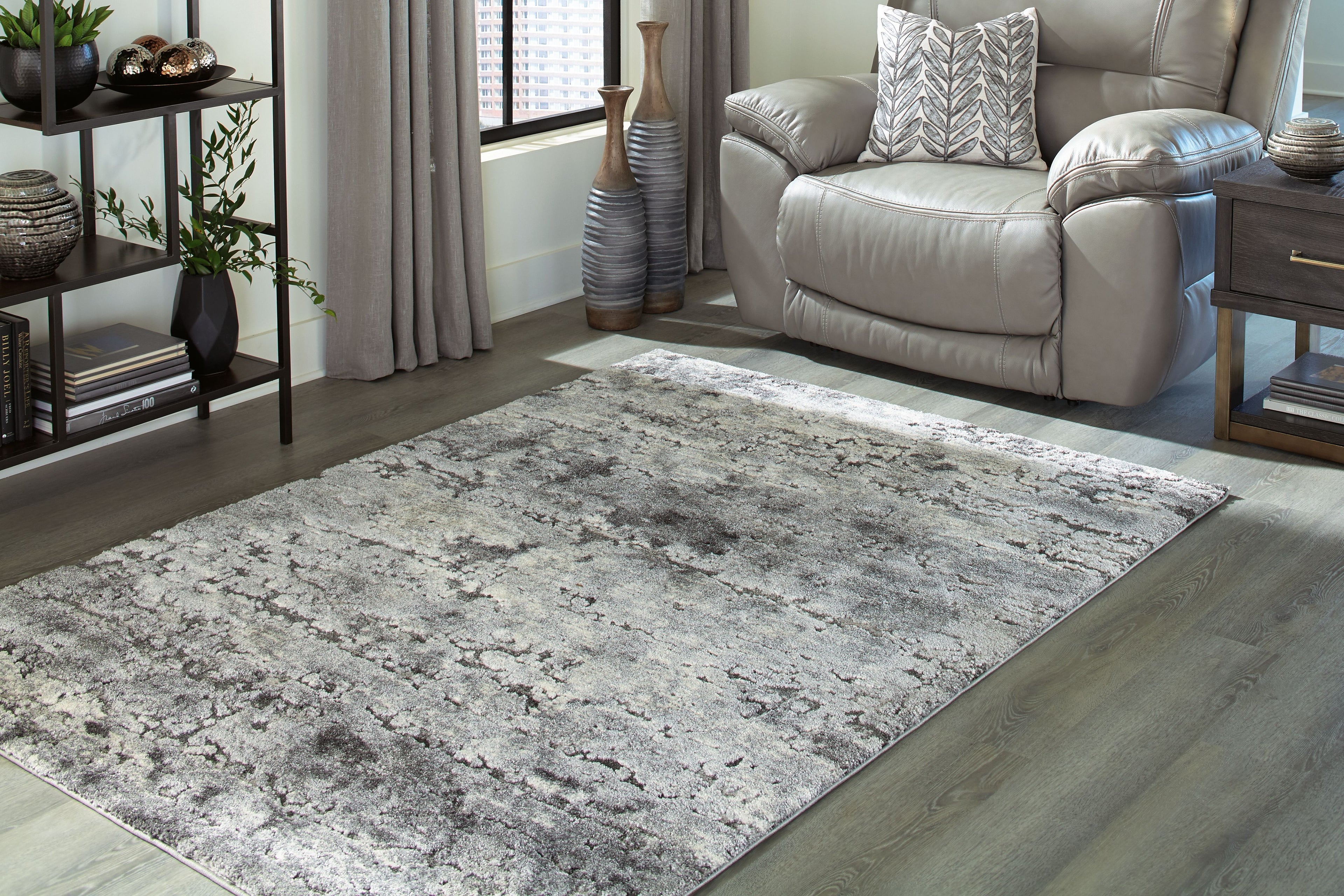 Dark gray distressed area rug, flat profile with stitched border and corner
