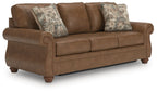 Brown sofa sleeper with three seat cushions and two patterned throw pillows
