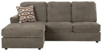 Gray sofa chaise with chaise extension, tufted back cushions, and patterned throw pillow