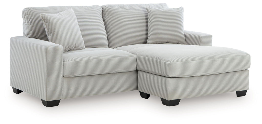 Gray sofa chaise with four back cushions and a chaise ottoman extension