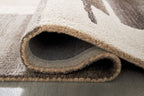 Area rug edge close-up showing low pile, dark interior, and beige binding