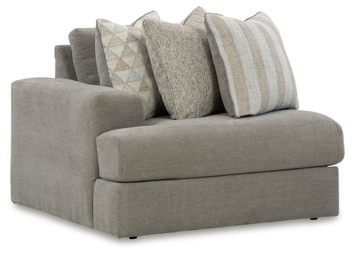 Gray upholstered corner chair with three decorative pillows and wide cushioned seat