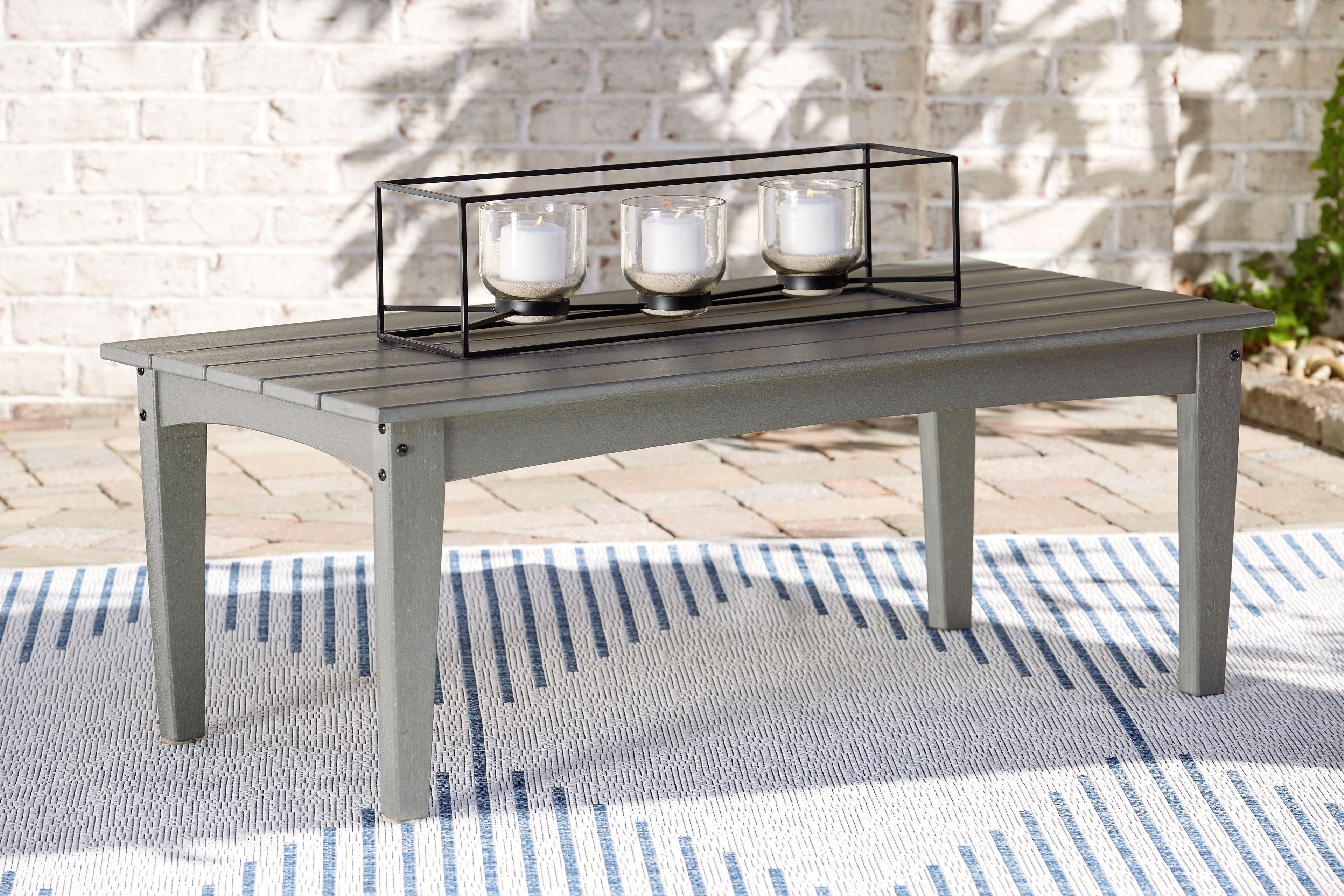 Rectangular outdoor coffee table with gray surface and black metal frame