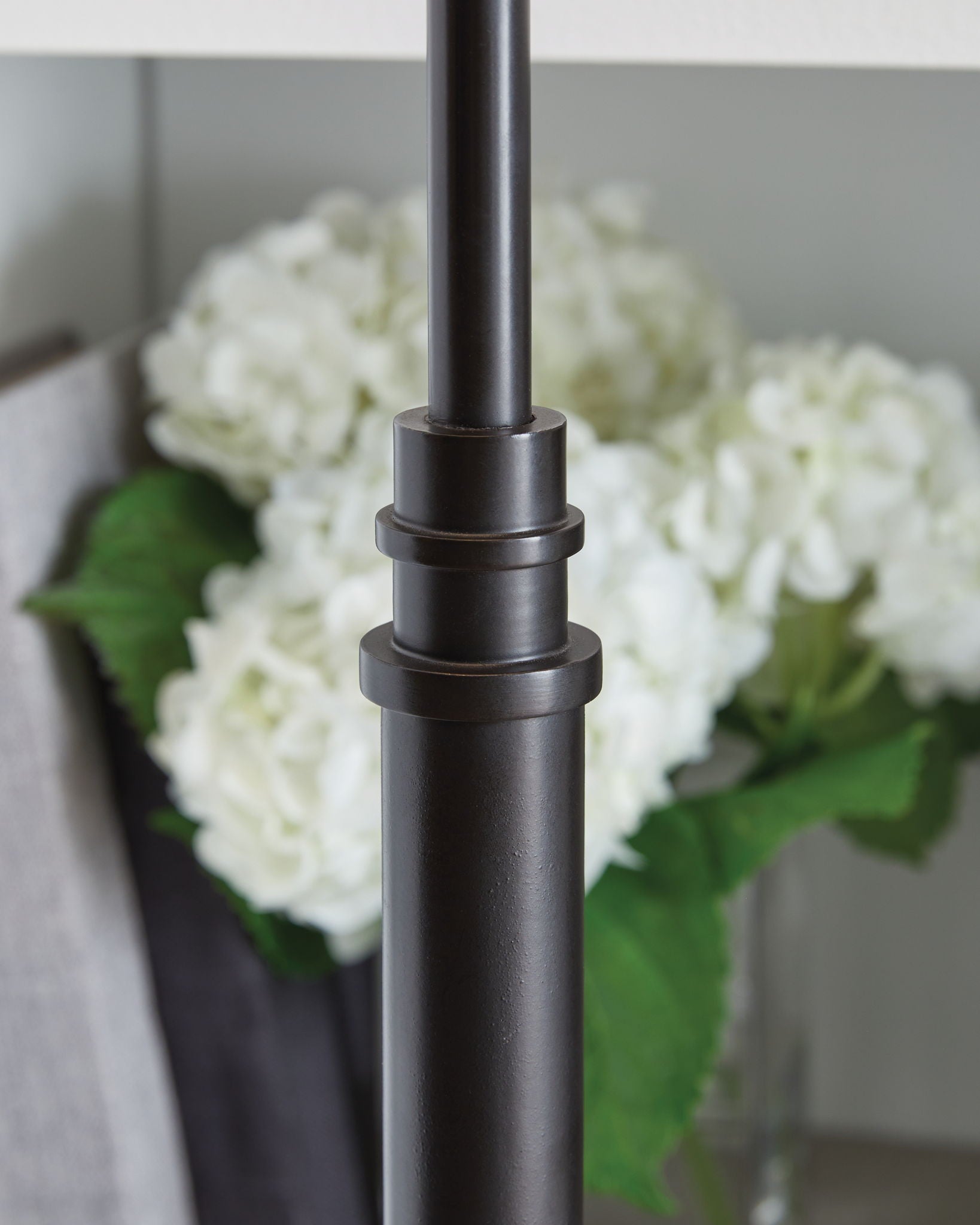 Black metal lamp pole with stacked ring details and smooth finish