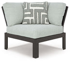 Gray outdoor corner chair with black frame, seat cushion, and patterned pillow