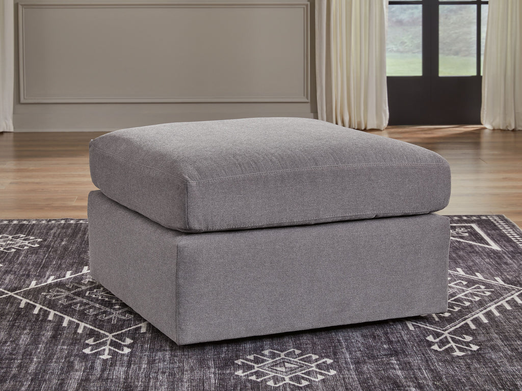 Gray upholstered accent ottoman with thick cushion and squared edges