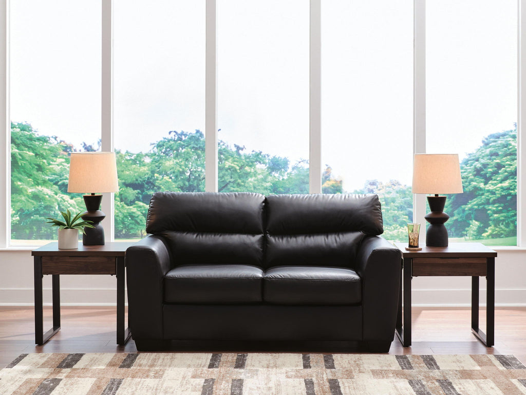 Dark leather-look loveseat with tufted back and two seat cushions, shown front view