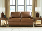 Brown loveseat sofa with padded back, two seat cushions, and nailhead trim along base
