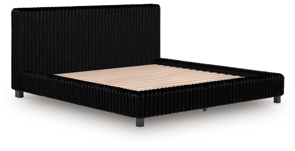 Upholstered bed frame with black ribbed sides and beige upholstered mattress base