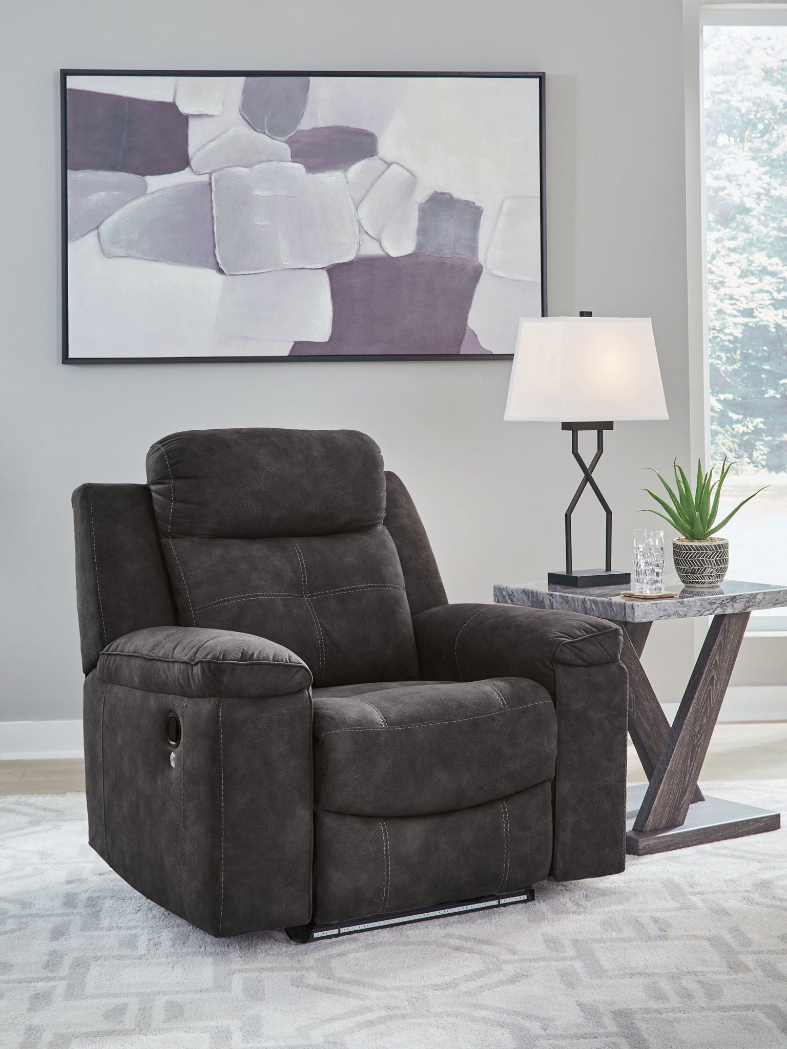 Charcoal zero-wall recliner with high back, cushioned arms, and smooth recline footrest