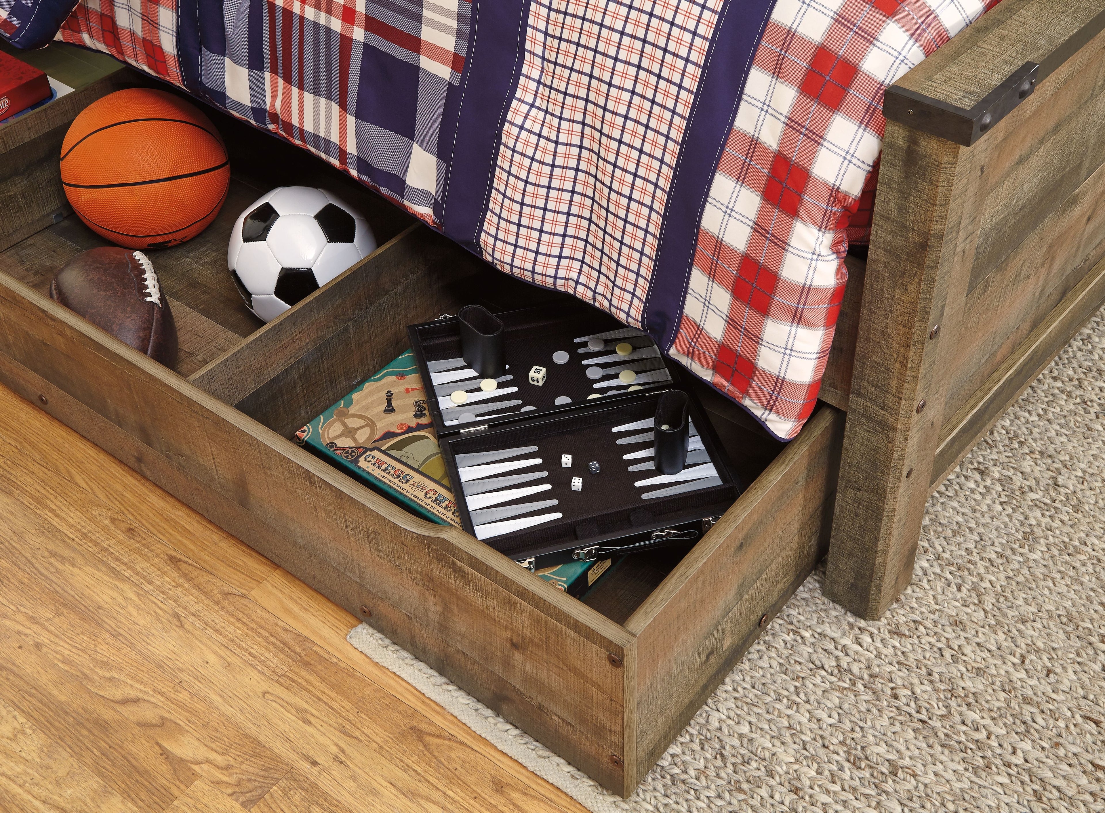 Brown storage drawer pulled out on a twin bookcase bed with small items inside