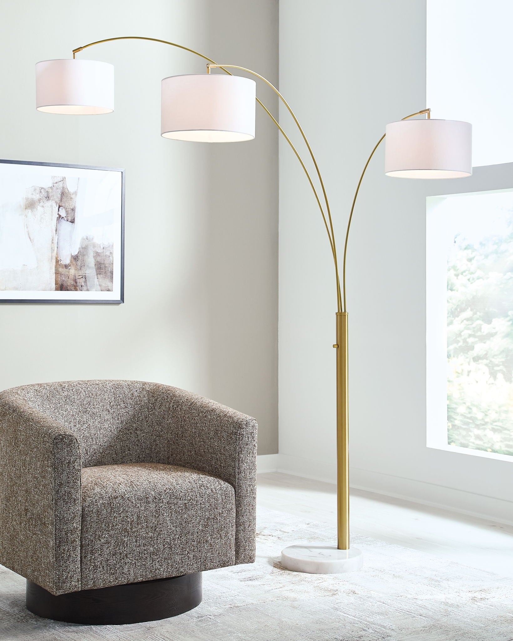 Gold arc floor lamp with three white drum shades and tall curved stand