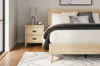 Tan queen panel headboard on bed frame with gray accent pillows and throw
