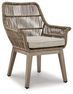 Beige wicker armchair with gray cushion, wide armrests and woven slatted back