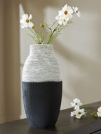 Black and white ceramic vase with white wildflower arrangement on tabletop