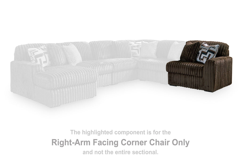 Chocolate corduroy corner chair section with patterned accent pillow and armrest