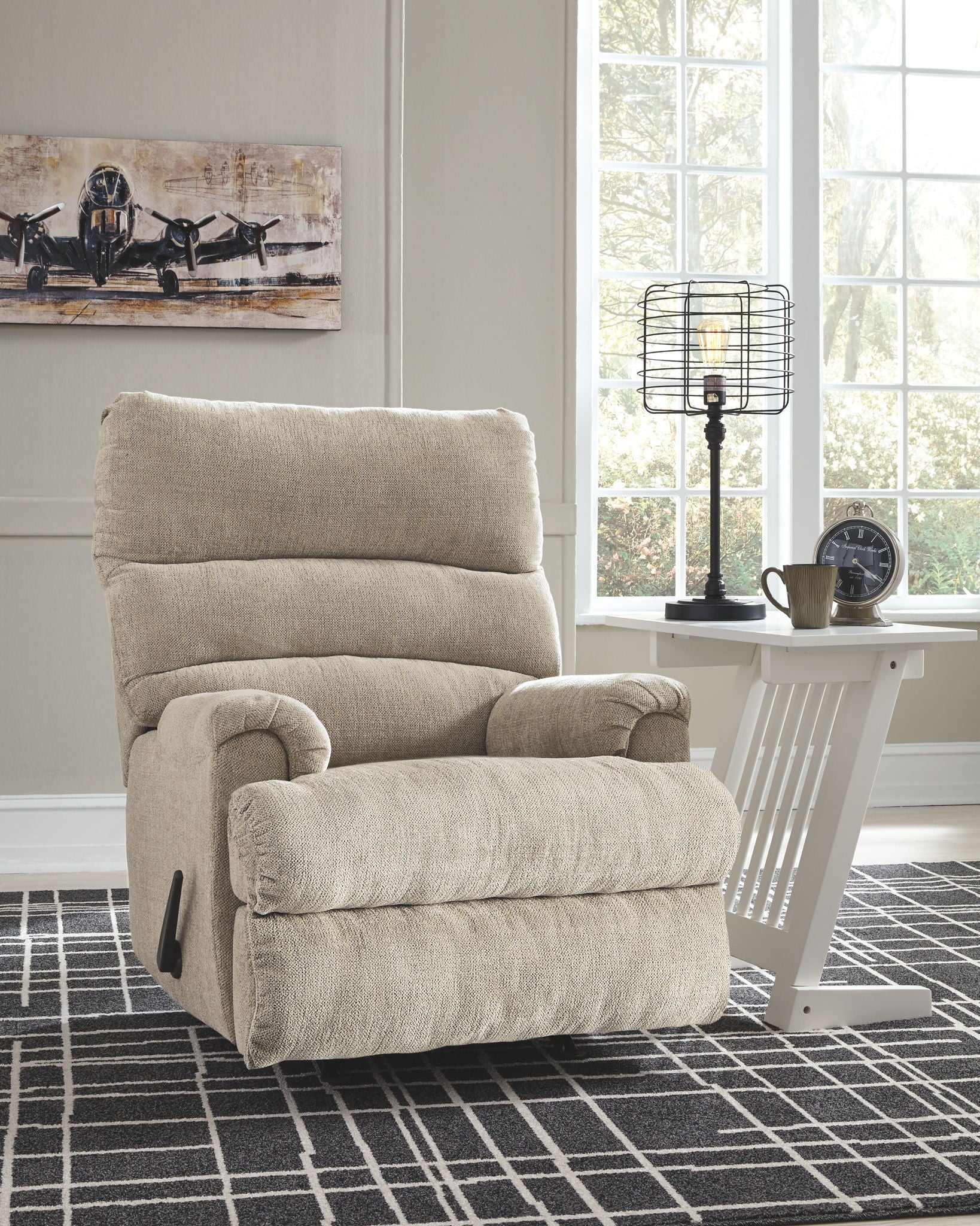 Rocking recliner chair with tall back cushion and padded arms in light fabric
